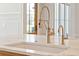 Elegant kitchen island featuring double faucets, marble countertop and white ceramic sink at 105 Peninsula Dr, Ravenel, SC 29470