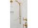 Modern shower featuring gold fixtures, marble tile, and a handheld shower head for a luxurious bathing experience at 105 Peninsula Dr, Ravenel, SC 29470