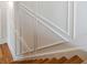 Close-up of staircase with decorative wall paneling and oak wood steps at 105 Peninsula Dr, Ravenel, SC 29470