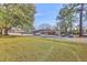 Well-maintained home with mature trees, a parking area, and a view of the surrounding neighborhood at 106 Mayrant St, Summerville, SC 29483