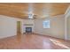 Cozy living room with a wooden ceiling, ceiling fan, fireplace, and abundant natural light through the window at 106 Mayrant St, Summerville, SC 29483