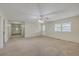Spacious living room featuring neutral carpet, a ceiling fan, and natural light from the windows at 106 Mayrant St, Summerville, SC 29483