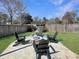 Scenic backyard with a fire pit area, Adirondack chairs, and lush greenery, perfect for outdoor gatherings at 107 Hainsworth Dr, North Charleston, SC 29418