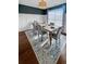 A well-lit dining room with modern decor, including a wooden table, gray chairs, and a stylish area rug at 107 Hainsworth Dr, North Charleston, SC 29418