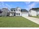 Beautiful two-story home featuring vinyl siding, a manicured lawn, and a long driveway leading to the garage at 107 Hainsworth Dr, North Charleston, SC 29418