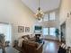 Spacious living room featuring high ceilings, a fireplace, a large chandelier, and a comfortable leather sofa at 107 Hainsworth Dr, North Charleston, SC 29418