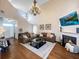 A bright living room showcasing high ceilings, a cozy fireplace, and comfortable leather sofas and hardwood flooring at 107 Hainsworth Dr, North Charleston, SC 29418