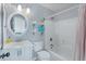 Bathroom features a shower-tub combo, decorative wallpaper, a modern vanity and a round mirror at 1104 Old Course Ln, Mount Pleasant, SC 29466