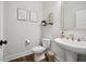 Well-lit bathroom with a toilet, pedestal sink and framed art at 1114 Donerail Ln, Johns Island, SC 29455