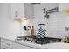 Close-up of modern kitchen featuring stainless steel pot filler, gas stove top and white shaker cabinets at 1114 Donerail Ln, Johns Island, SC 29455