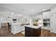 Open concept kitchen with stainless steel sink, island, and views into the living room featuring abundant natural light at 1114 Donerail Ln, Johns Island, SC 29455