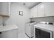 Bright laundry room features modern appliances and ample white cabinetry for storage at 1114 Donerail Ln, Johns Island, SC 29455