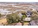 Aerial view highlighting waterfront properties with private docks, green spaces, and serene estuary views at 12 Trachelle Ln, Charleston, SC 29407