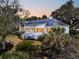 Aerial view of a beautiful house featuring solar panels and lush gardens at twilight at 12 Trachelle Ln, Charleston, SC 29407
