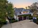 Aerial view of charming home exterior at dusk, showing attached garage with green vines and basketball court at 12 Trachelle Ln, Charleston, SC 29407