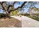 Inviting driveway leading to a home with a well-manicured lawn and attached garage at 12 Trachelle Ln, Charleston, SC 29407