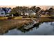 Beautiful waterfront home with private dock, manicured lawn, and mature trees, providing a tranquil retreat at 12 Trachelle Ln, Charleston, SC 29407