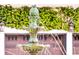 Close-up of tiered fountain with pineapple topper in front of a two-car garage with climbing vines at 12 Trachelle Ln, Charleston, SC 29407