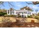 Charming white home with black-framed windows and lush landscaping in a serene setting at 12 Trachelle Ln, Charleston, SC 29407