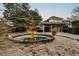 Inviting home exterior at dusk featuring a tiered fountain, lush landscaping, and an attached two-car garage at 12 Trachelle Ln, Charleston, SC 29407