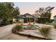 Inviting home exterior at dusk featuring a tiered fountain, lush landscaping, and an attached two-car garage at 12 Trachelle Ln, Charleston, SC 29407