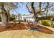 Landscaped front yard featuring a unique tree swing and mature trees at 12 Trachelle Ln, Charleston, SC 29407