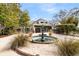 Inviting home exterior featuring a tiered fountain, lush landscaping, and an attached two-car garage at 12 Trachelle Ln, Charleston, SC 29407