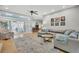 Open living room features hardwood floors, gray sofa, area rug, and sliding glass doors at 12 Trachelle Ln, Charleston, SC 29407