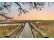 A serene boardwalk view at sunset, highlighting the beauty of the marsh at 12 Trachelle Ln, Charleston, SC 29407