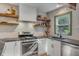 Bright kitchen showcasing stainless appliances, granite counters, white cabinets, and wood shelving at 1228 Penny Cir, Mount Pleasant, SC 29464