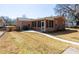 Backyard view with a brick house, screened-in porch, walkway, sparse lawn, and peaceful outdoor atmosphere at 1258 Redeemer Dr, Hanahan, SC 29410