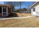Backyard showcasing a brick house, screened-in porch, walkway, sparse lawn, bare trees, and peaceful atmosphere at 1258 Redeemer Dr, Hanahan, SC 29410