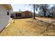 Backyard view showcasing a brick house, screened-in porch, sparse lawn, mature trees, and a quiet outdoor setting at 1258 Redeemer Dr, Hanahan, SC 29410