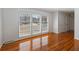 A well-lit living room with hardwood floors, large windows, and white blinds at 1258 Redeemer Dr, Hanahan, SC 29410