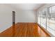 An empty living room with hardwood floors, large windows with blinds, and white walls at 1258 Redeemer Dr, Hanahan, SC 29410