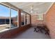 Enclosed sunroom featuring brick accents, windows, a ceiling fan, and a wooden picnic table at 1258 Redeemer Dr, Hanahan, SC 29410