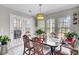 Light-filled dining area with a decorative chandelier, table with six chairs and a view to the backyard at 126 Moon Shadow Ln, Summerville, SC 29485