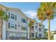 Attractive condo exterior featuring multiple levels, screened patios, and tropical landscaping on a beautiful day at 1300 Park West Blvd # 418, Mount Pleasant, SC 29466