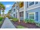 View of condo exteriors with sidewalks and lush landscaping featuring a walkway, mature trees, and shrubbery at 1300 Park West Blvd # 418, Mount Pleasant, SC 29466