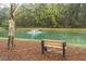 The community pond features a relaxing bench with lush landscaping and a soothing fountain view at 1300 Park West Blvd # 418, Mount Pleasant, SC 29466