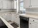 Well-lit kitchen with stainless steel sink, black dishwasher, and white cabinets at 1407 Congressional Blvd, Summerville, SC 29483