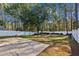 Large, fenced backyard with a concrete patio, bordered by mature trees and a privacy fence at 1452 Water Edge Dr, Charleston, SC 29492