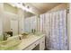 A bathroom with a glass vessel sink, white vanity, and floral shower curtain at 1452 Water Edge Dr, Charleston, SC 29492