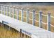 Detailed view of a weathered wooden boardwalk with white rope railings stretching through golden marsh grasses at 1717 Vireo Ct, Johns Island, SC 29455