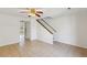 Bright living room showcasing neutral tile flooring, ceiling fan, and staircase access at 1735 Boone Hall Dr # K14, Charleston, SC 29407