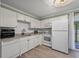 Clean kitchen with all-white cabinets, a subway backsplash, modern appliances, and access to the outdoors at 1836 Mepkin Rd # D4, Charleston, SC 29407