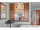 Wet bar with custom wood cabinetry and glass shelving at 1902 Long Bend Dr # 1B, Seabrook Island, SC 29455