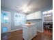 Well-lit kitchen featuring white cabinets, an island, and a view into the dining area at 2009 Arundel Pl, Mount Pleasant, SC 29464