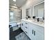 Stylish bathroom featuring dual sinks, modern lighting, and a glass-enclosed shower/tub at 2012 Forest Ave, North Charleston, SC 29405