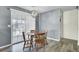 Cozy dining area with a wooden table, four chairs, and sliding glass doors with sheer curtains at 203 Birmingham Dr, Summerville, SC 29486